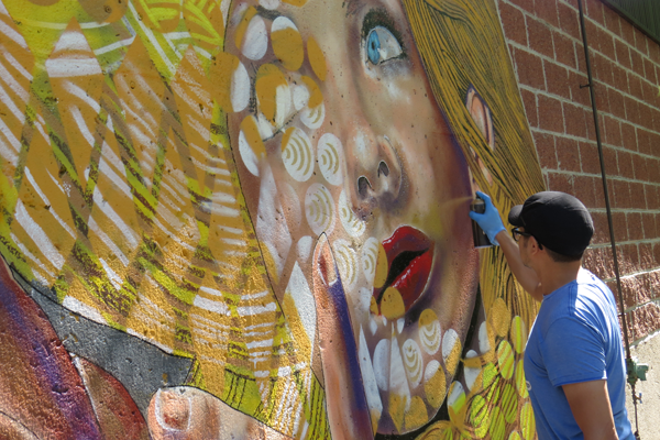 Chuck Tingley works on a permanent mural at Artpark in Lewiston. 