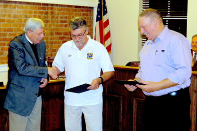 Mayor Terry Collesano, far left, presented DPW Superintendent Terry Brolinski (center) and DPW mechanic Robert Crewe with certificates recognizing 25 years of service to the municipality.