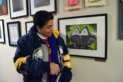 Lisa G. looks at her artwork.