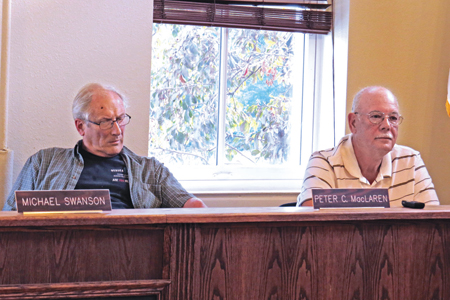 Zoning Board of Appeals members Peter MacLaren, left, and H. John Ritter listen as residents discuss Ellicott Development's plaza proposal variance requests. Shown below is a portion of the property's southeast corner.