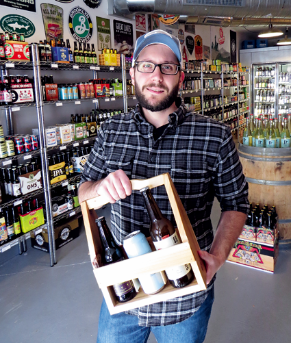 Chris Budde displays a locally made holder, which will be on sale on Small Business Saturday, Nov. 26, at Brewed and Bottled, located at the corner of Center and North Fourth streets, Lewiston.