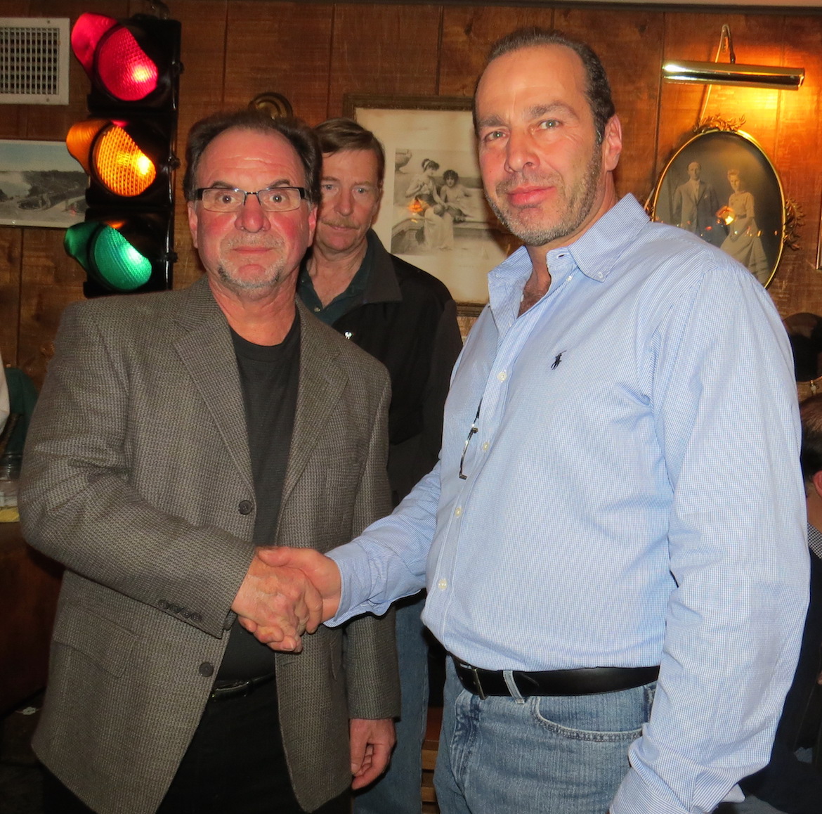 Rob Morreale and Dave Trane shake hands after hearing the Election Day results Tuesday inside Apple Granny Restaurant in Lewiston.