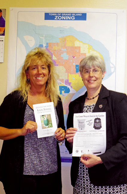Assistant Civil Engineer Lynn Dingey, left, and Town Supervisor Mary Cooke hold the forms for rain barrels and compost bins. (Photo by Alice E. Gerard)