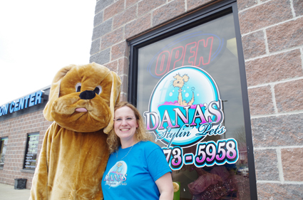 Carver and Tim the Dog are outside their front door and the open for business sign.