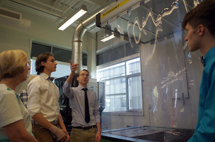 Grand Island High School student Eric Meng describes the machines in the Grand Island High School technology wing to Diane Tiede, who toured the wing Monday. Adam Crist and Connor Pignatora, right, also guided the tour.