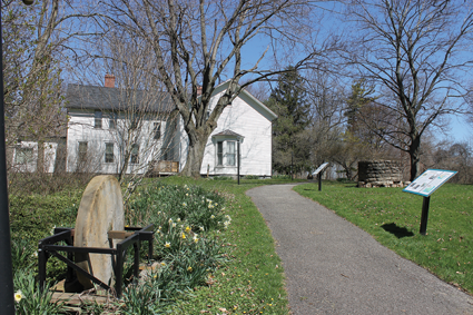 A grinding stone, brought to the site and placed on a steel base as part of an Eagle Scout project facilitated by Ricky Hoover in 2014.