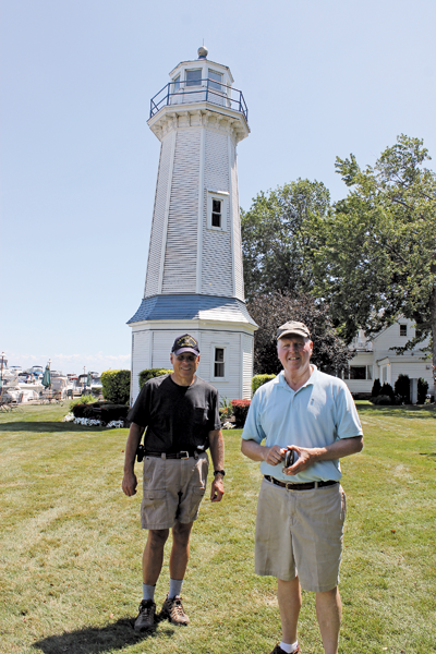Paul Leuchner and Tom Frauenheim stand in front of the Buffalo Launch Club range light at 503 East River Road on Grand Island. The two are researching the origin of the lighthouse and seeking photos and recollections of those who may know about its history. They are planning an educational presentation on the lighthouse, where they will invite public input. (Photo by Karen Carr Keefe)
