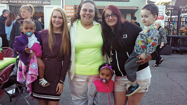 "Footprints on the Future" founder Sandy Quinn (center) poses for a photo with two of the group's original members, Samantha Miller (left) and Kayla Leiser, and their children.