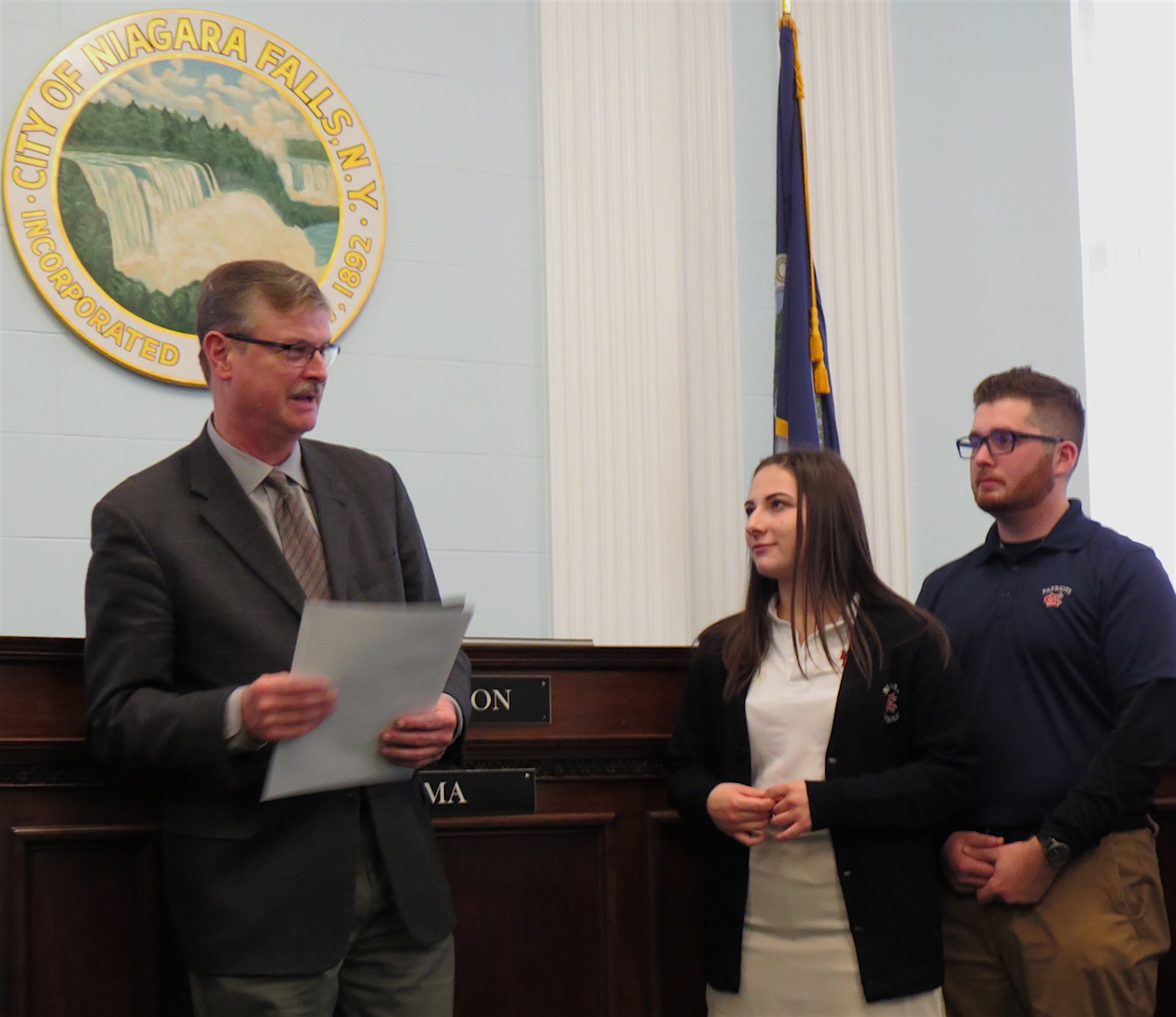 Niagara Catholic seniors Cora Wright and Alex Ackley listen as Niagara Falls Mayor Paul Dyster talks about #GivingTuesday.