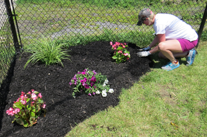 Amanda Tabaczynski works on a flowerbed at the Niagara Falls Boys & Girls Club.
