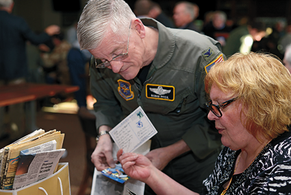 Col. (retired) Robin Pfeil, 914 Airlift Wing, former vice commander, and Edith Fose, general manager, base lodging, look through old postcards and photos.