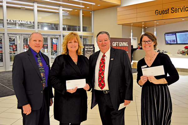 Recipients hold up their donations after the 