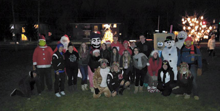 The carolers pose for a pictures with the North Tonawanda High School mascot (Lumberjack) during the tree-lighting ceremony last year. (Photo courtesy of XMAS Trailer's Facebook page)