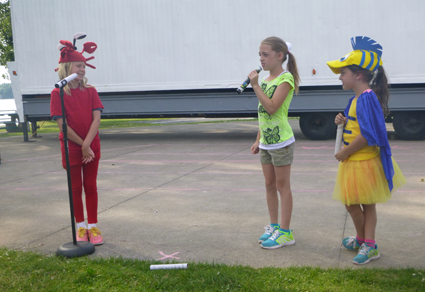 Alanna Banas, left, playing Sebastian, speaks to Alyssa Marella, playing Ariel, and Abigail Marella, playing Flounder, during a rehearsal.